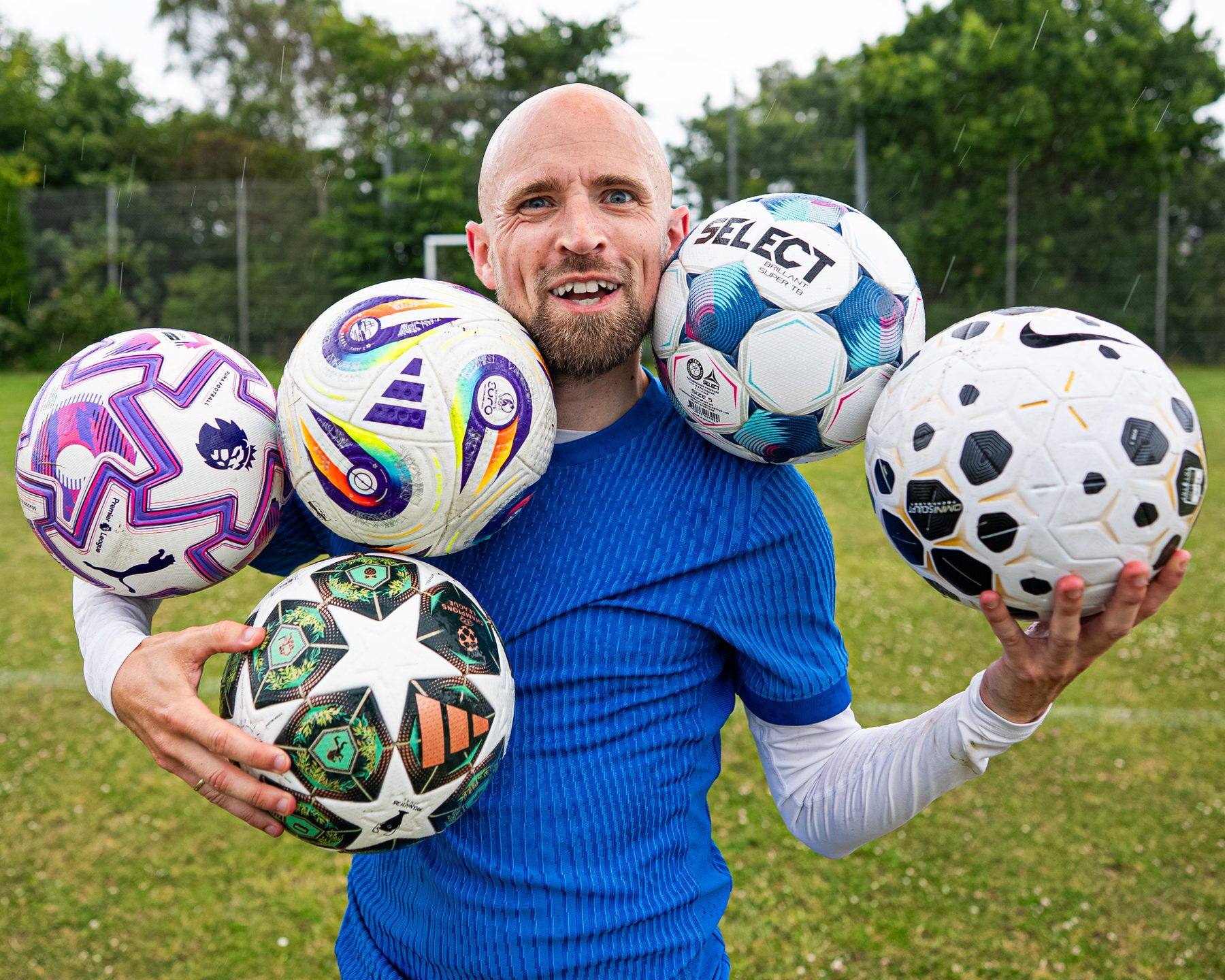Jay Mike holding five footballs on a training pitch